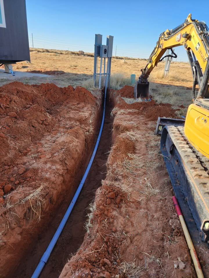 Underground conduit trench with Bobcat excavator at job site